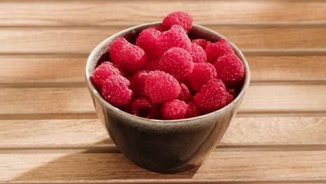 raspberries in a bowl on a wooden table