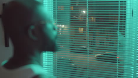 African-American-Man-Looking-through-Window-in-Night