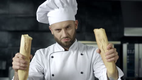 Male-chef-breaking-french-bread-in-slow-motion.-Closeup-hands-breaking-bread.