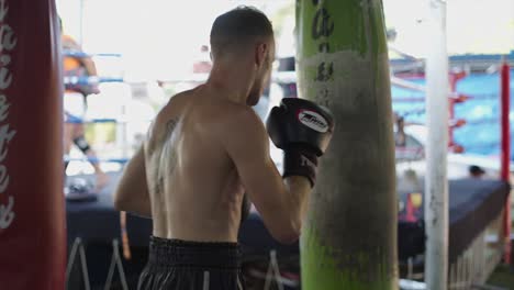 man training with punching bag in a boxing gym