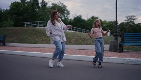 madre e hija bailando en el parque