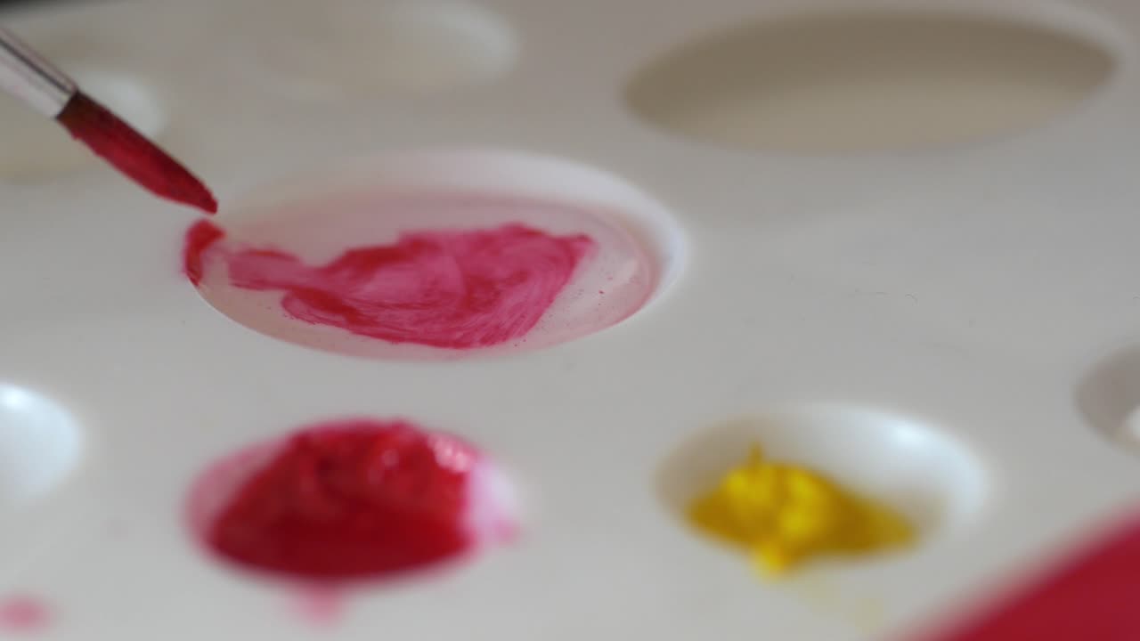 Painting with red and yellow colors on a palette