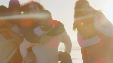 Grupo-De-Amigos-Teniendo-Juntos-Una-Carrera-A-Cuestas-En-La-Playa-De-Invierno