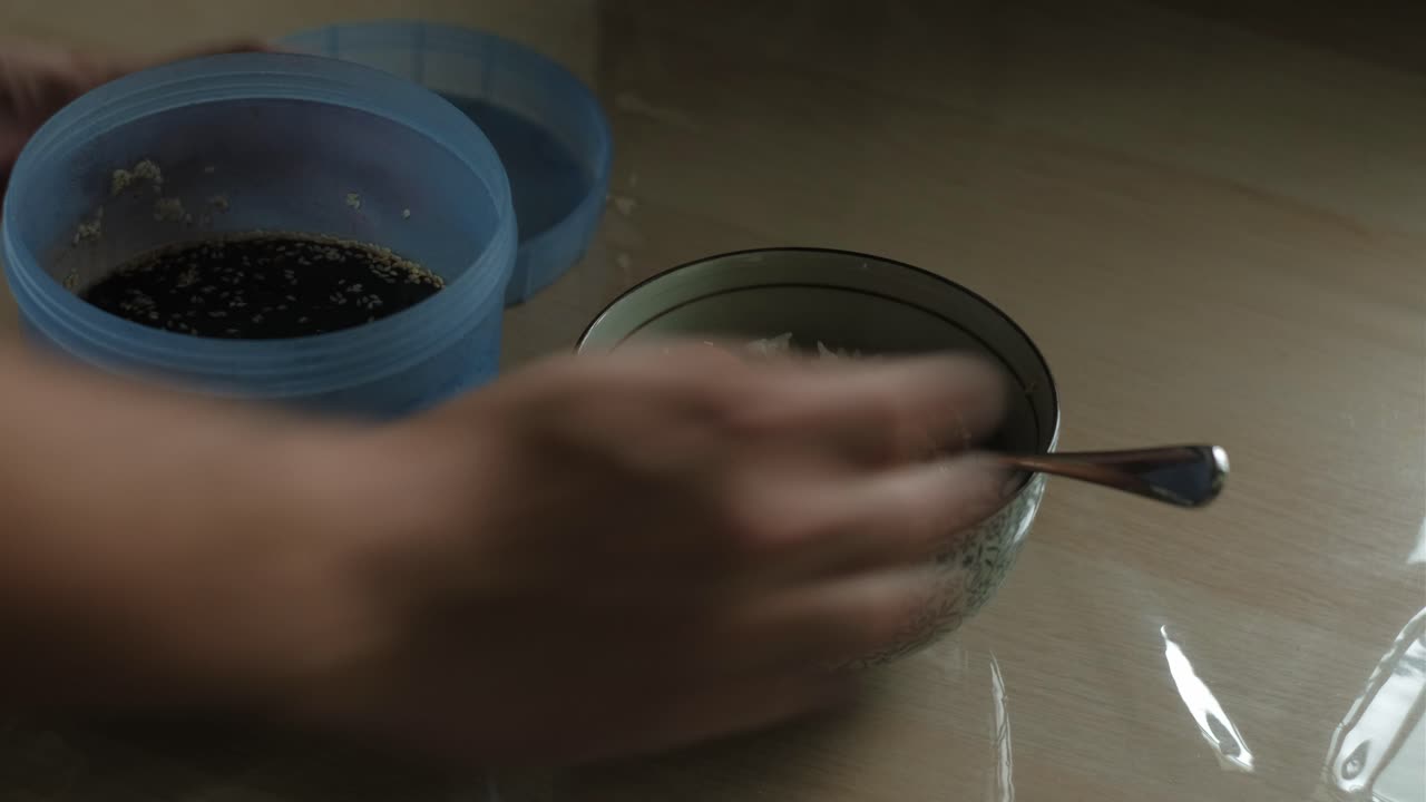 Adding soy sauce marinade to Korean Soy Egg rice bowl. -closeup static shot