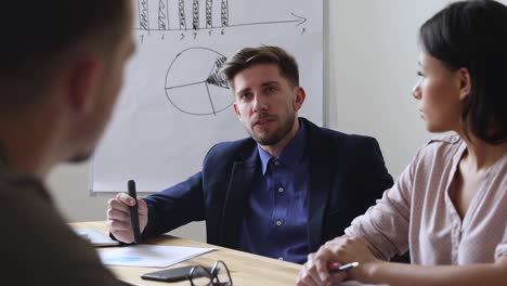 joven empresario centrado compartiendo ideas de negocio con sus colegas.