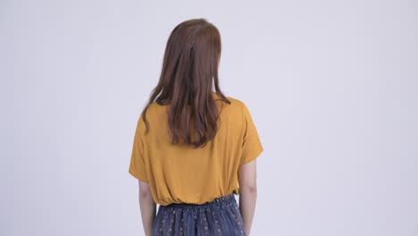 rear view of young asian woman thinking and waiting