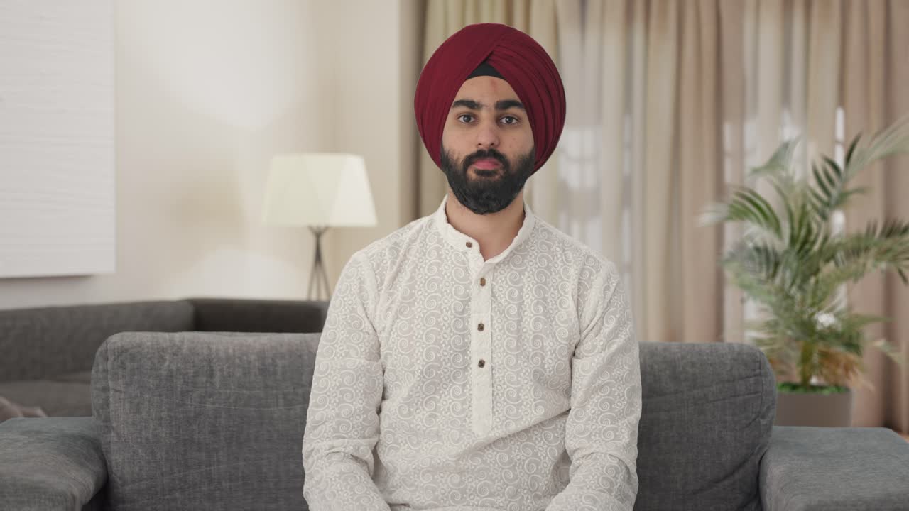 Uomo indiano Sikh deluso che mostra il pollice verso il basso