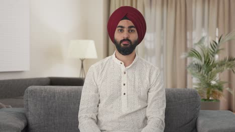 hombre indio sikh decepcionado mostrando los pulgares hacia abajo
