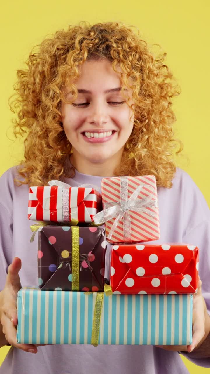Woman showing a stack of colorful wrapped gifts