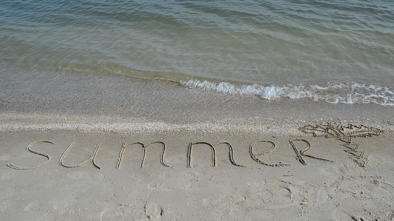 Inskription 'sommar' på sanden, stranden. Fotografering på stranden.