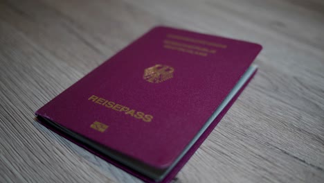 german passport is thrown on a wooden table