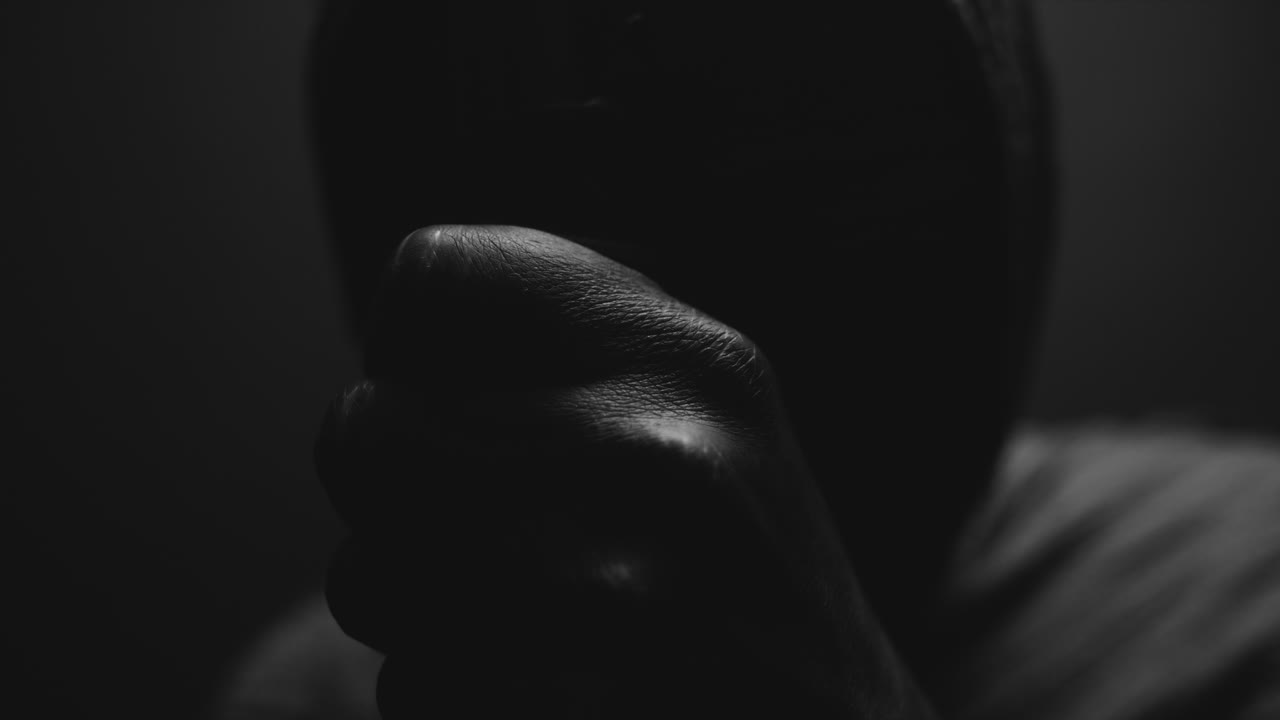 A mummified woman against the dark background pose with the walking staff