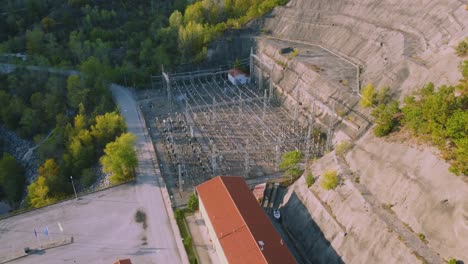 Establishing-shot-of-electricity-substation-next-to-large-dam