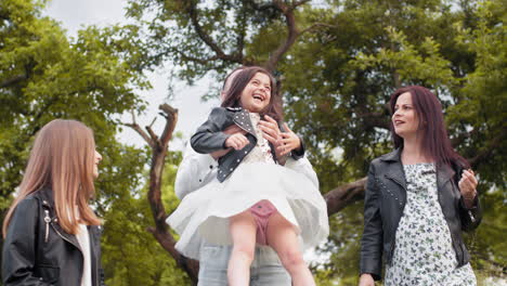 father holding daughter in park