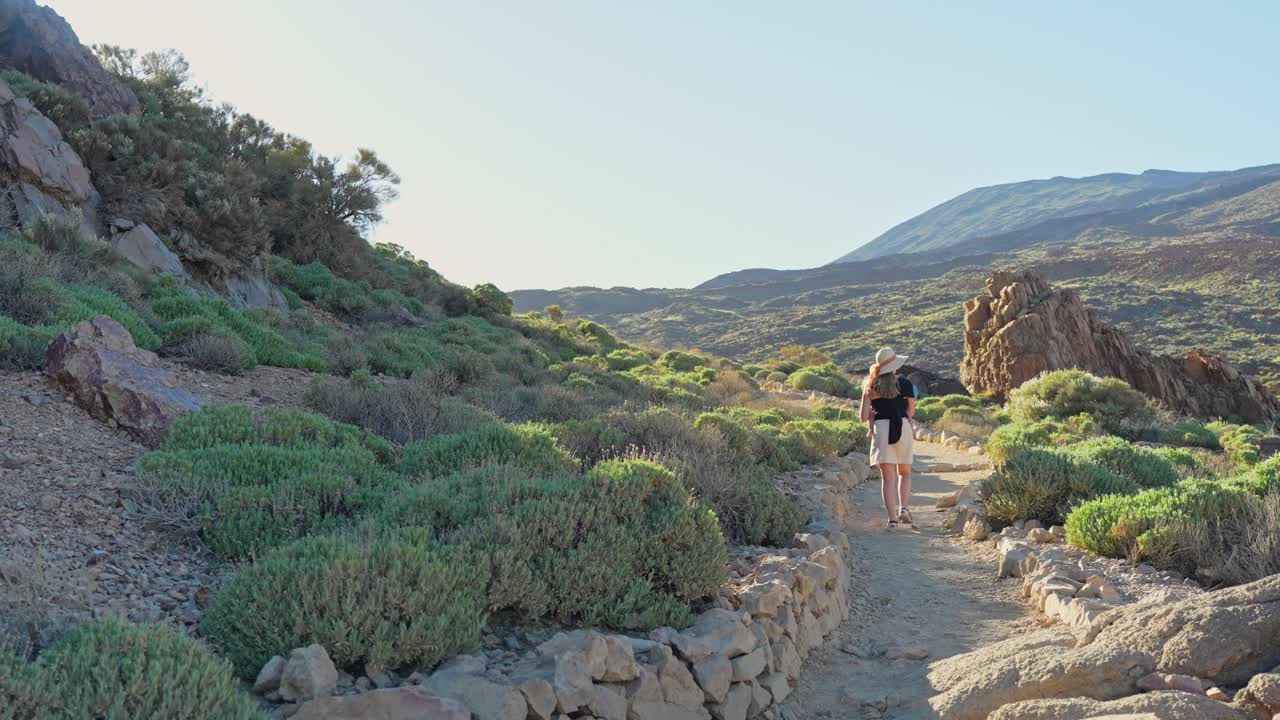 joven mujer aventurera caminando en el parque nacional del teide, vista trasera