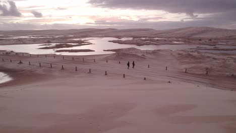 Gente-Caminando-En-La-Pista-Dentro-De-Las-Dunas-De-Arena-Y-La-Playa-De-Stockton-En-Nueva-Gales-Del-Sur