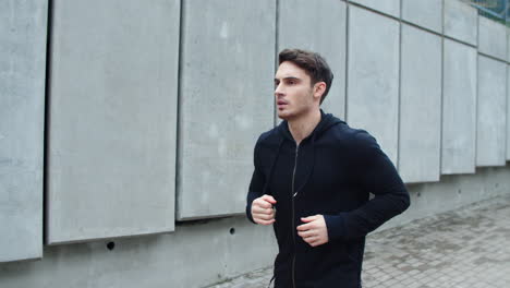 Portrait-of-handsome-guy-jogging-on-urban-street