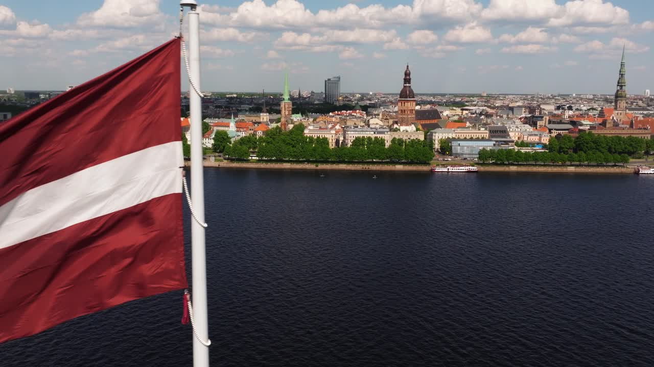 Vista aerea ravvicinata della bandiera lettone che sventola al vento - Riga, Lettonia sullo sfondo
