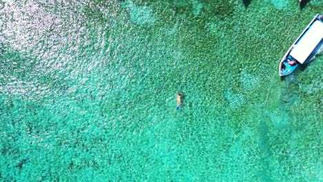 Hombre-De-Vacaciones-Capturado-Desde-El-Aire-Buceando-Con-Botes-En-El-Hermoso-Y-Exótico-Lugar-De-Vacaciones-Remoto-De-Tailandia-Cerca-Del-Arrecife-De-Coral-Con-Impresionantes-Aguas-Cristalinas