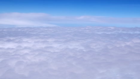 passenger view from airplane flying above the clouds