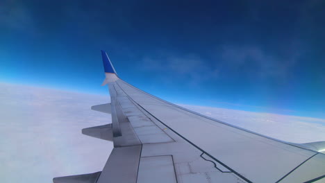 tenues nubes flotan más allá de las ventanas de un avión justo por encima del ala
