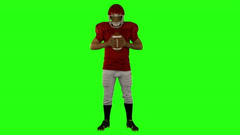 red serious american football player posing
