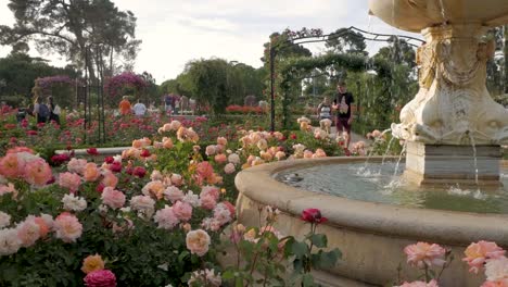 detail shot of fuente del fauno with tourists walking up to take a picture of it in la rosaleda, retiro park.