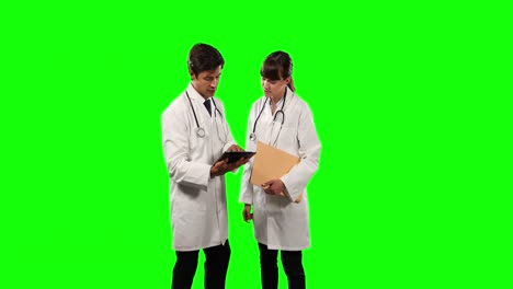 Ärzte-In-Der-Vorderansicht-überprüfen-Ihre-Ergebnisse-Auf-Einem-Digitalen-Tablet-Mit-Grünem-Bildschirm