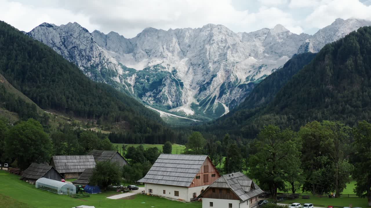 vista aérea del valle alpino con granja rústica en frente, jezersko, eslovenia, alpes europeos, paisaje montañoso escénico