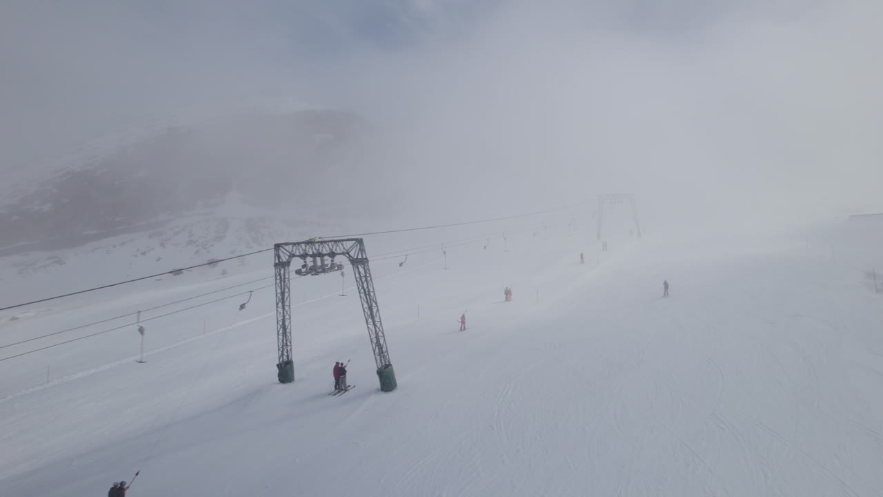 오스트리아의 스키 리프트 옆에 있는 안개 낀 날 공중 비행 스키어 스키 눈 덮인 슬로프