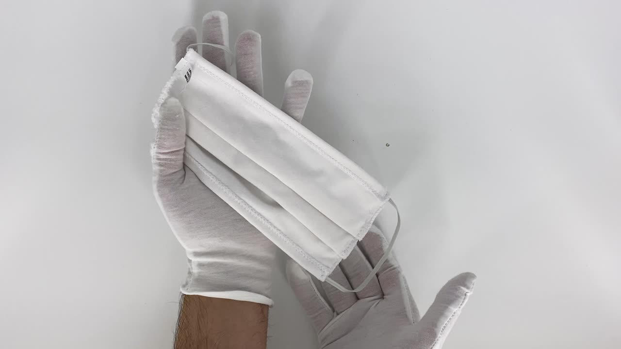 mostrando y probando una mascarilla de algodón blanco
