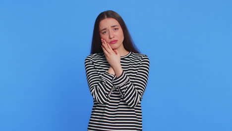 young woman touching cheek closing eyes with expression of terrible suffer from painful toothache