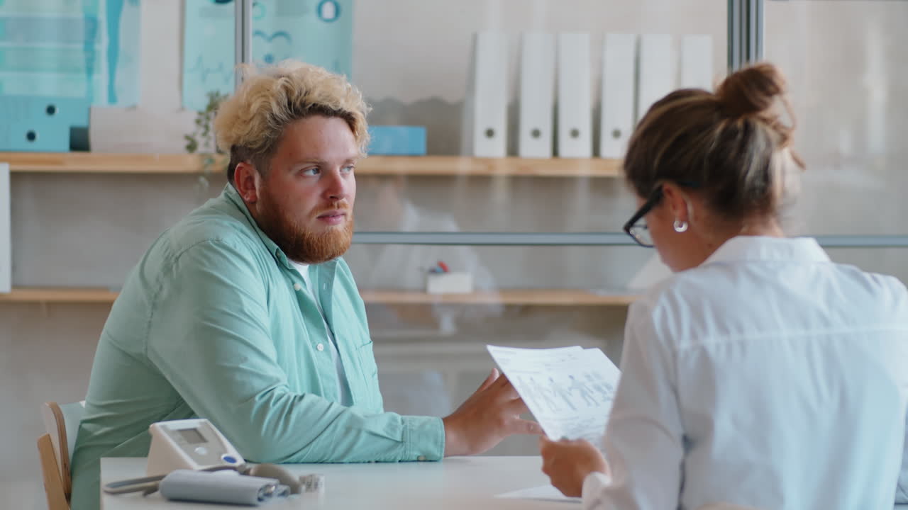 Overweight Man Speaking with Female Doctor in Clinic