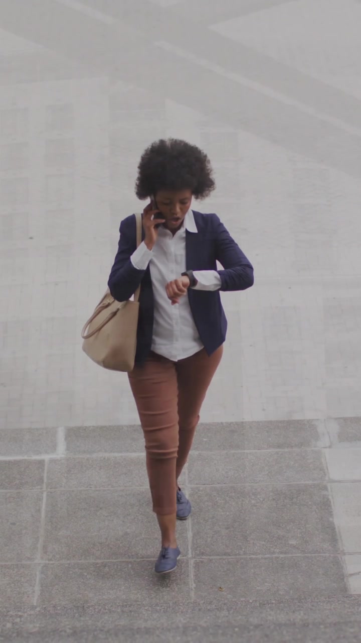 Animazione di numeri su una donna d'affari afroamericana che parla al telefono mentre sale le scale.