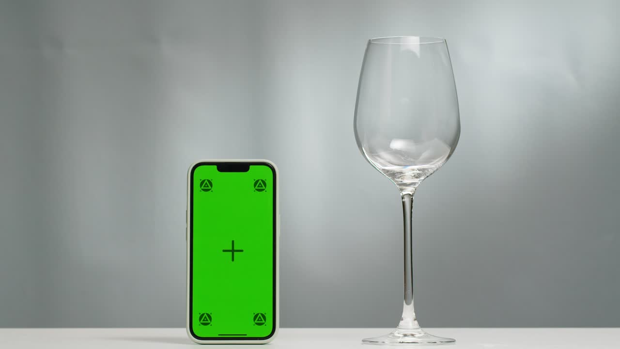 Rose Orange or white wine bottle and glass with chroma key green screen phone smartphone, application app, pouring of ecological natural wine. Cheers, hands with wine glasses, drinking alcohol.