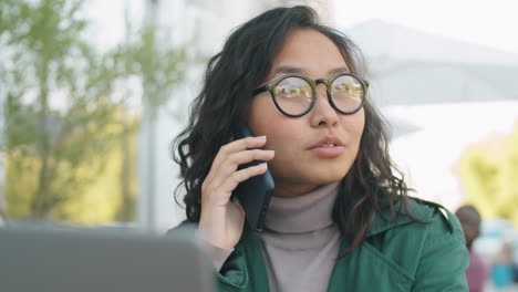 mujer de negocios asiática hablando por teléfono móvil al aire libre