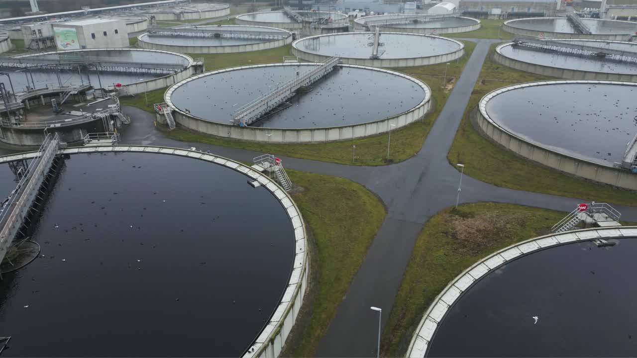 Drone aerial showing multiple circular wastewater tanks arranged in industrial grid layout
