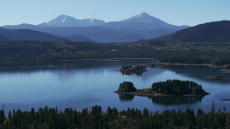 early fall colors lake dillon islands colorado aerial cinematic drone morning view frisco breckenridge silverthorne ten mile range calm reflective water yellow aspen trees to the right movement