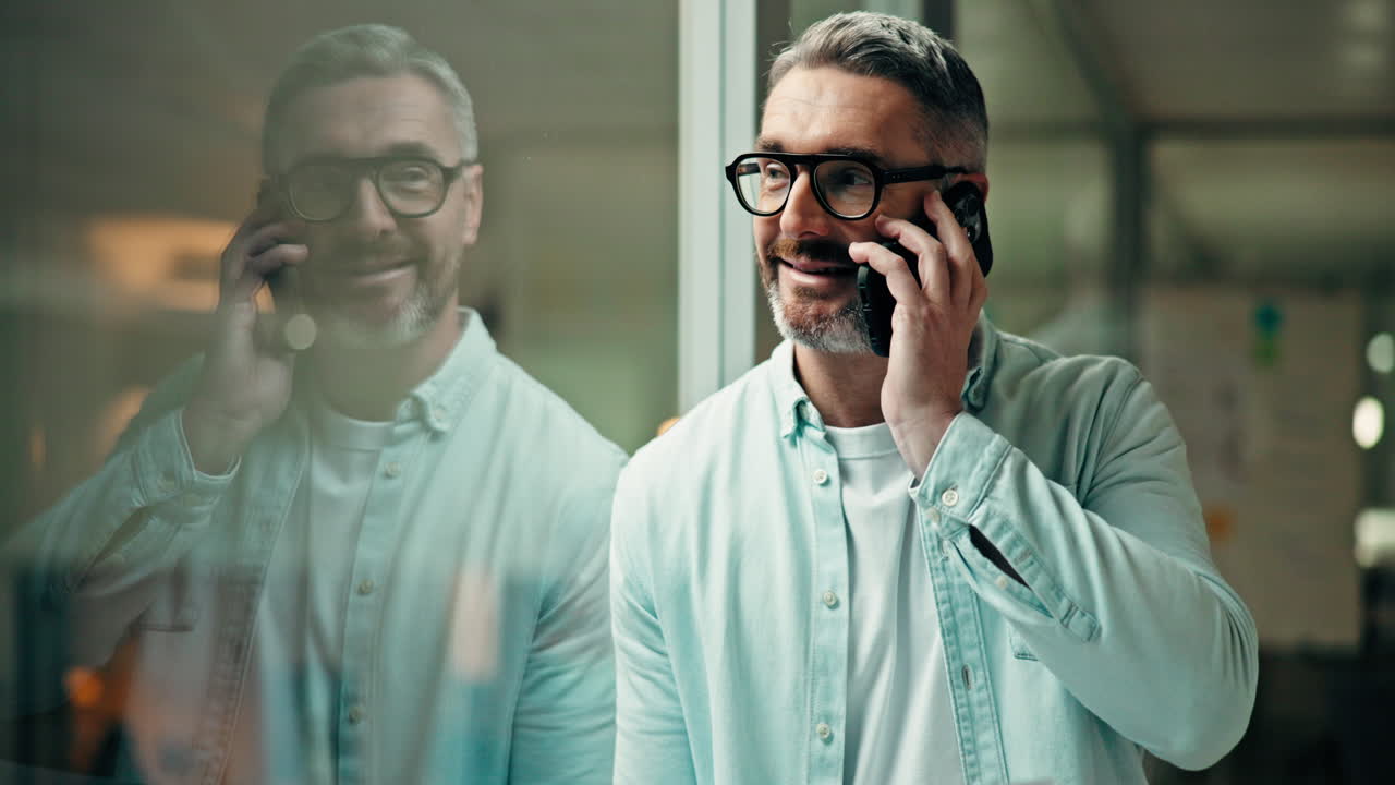 Mand taler i telefon ved et vindue