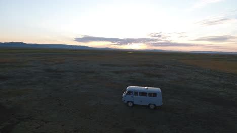 Aerial-drone-shot-following-a-russian-van-in-mongolian-steppes-during-sunrise