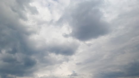 azure sky hardly ever seen behind the grey cloudscape. grey clouds accumulating in the atmosphere. low angle view. timelapse.