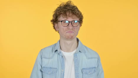 redhead young man head shake no sign, yellow background