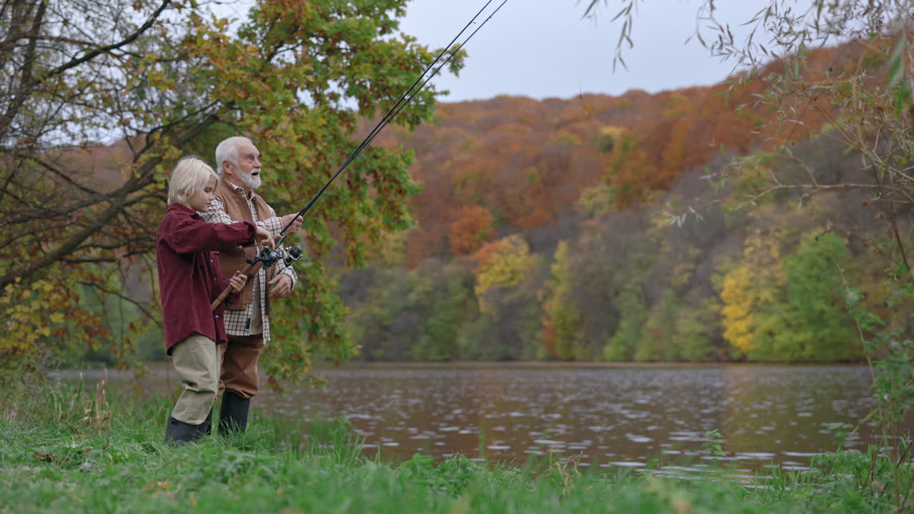 Grandfather and Grandchild Fishing by a Lake in Autumn