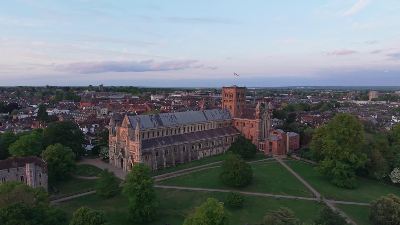 Elegant medium-distance orbit drone footage of St Albans Cathedral, highlighting the church and its beautiful surrounding landscape