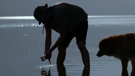 pescador limpiando un pez muerto en el río 4k