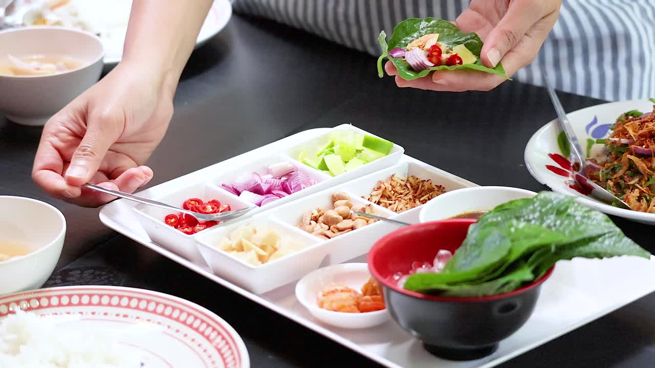 손으로 전통적인 태국 미앙 을 조심스럽게 포장하는 맛있는 잎