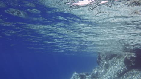 pelagic zone of crystal clear waters and sunken rocks in paralia emplisi beach, in greece- underwater shot