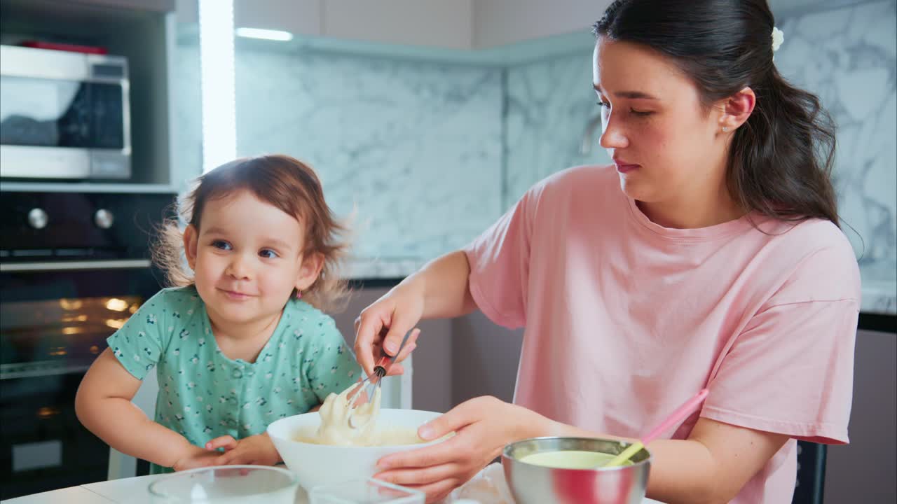 A Heartwarming Moment in the Kitchen: A Joyful Mother and Her Child Engage in Baking Together, Creating Delicious Memories and Cherishing Quality Family Time