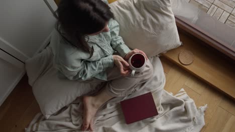 frau, die sich mit einem buch und einer tasse tee entspannt