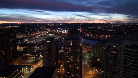 Cityscape-at-dusk-with-mountains-on-horizon